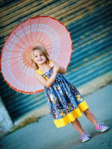 little girl wearing a toddler dress inspired by gray and yellow, the colors of 2021